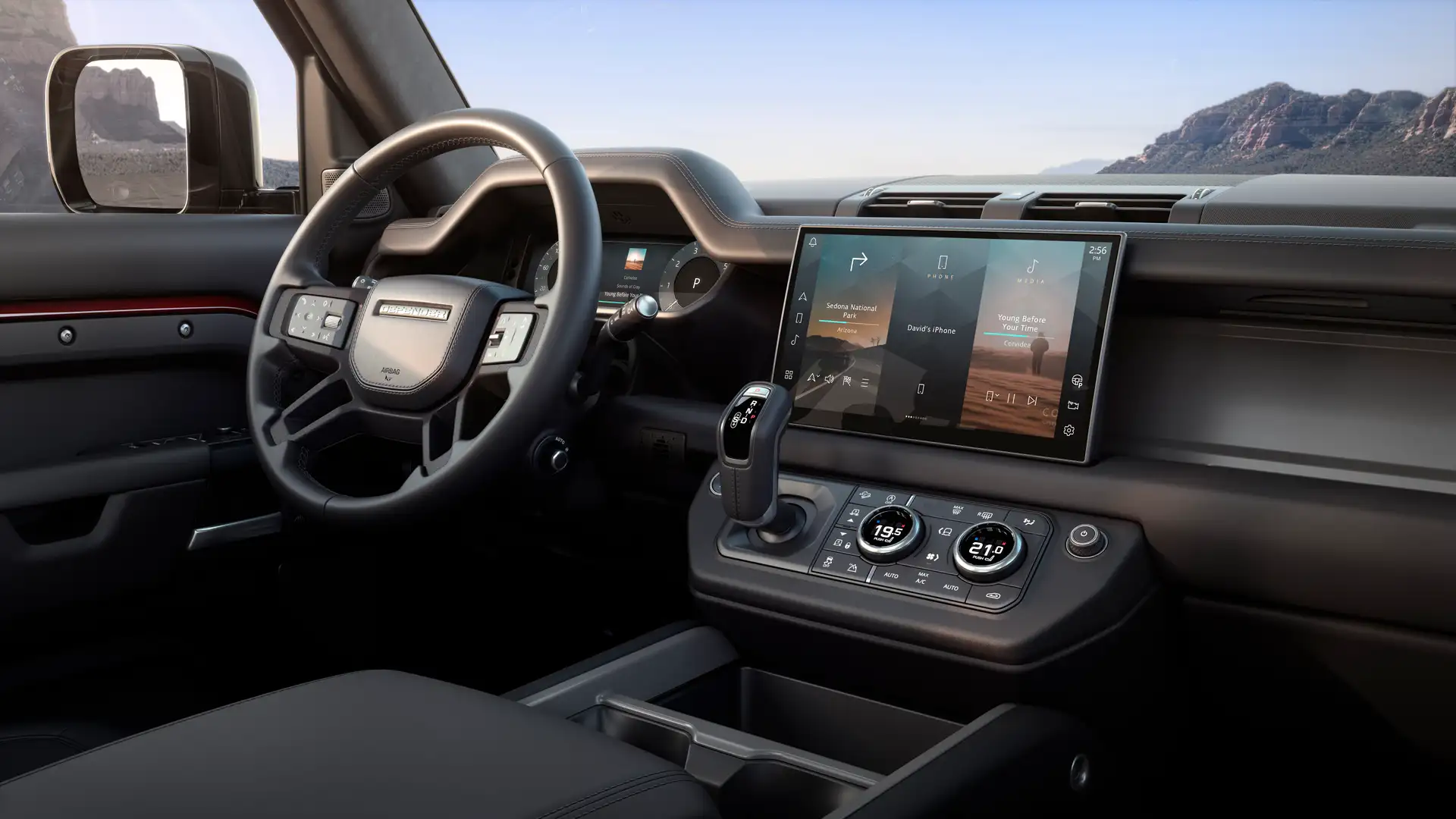 The steering wheel and interior of a Land Rover Defender.